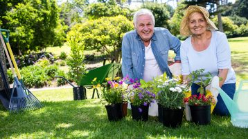 Portrait of happy senior couple gardening in the park on a sunny